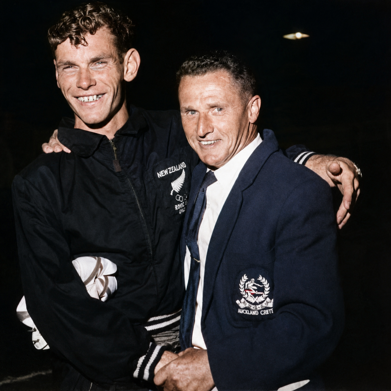 Arthur Lydiard in an Auckland Centre blazer with his arm around a young New Zealand Olympian in team uniform